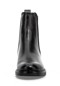 Bottine en cuir noir brillant avec bout arrondi et semelle plate, vue de face sur fond blanc.