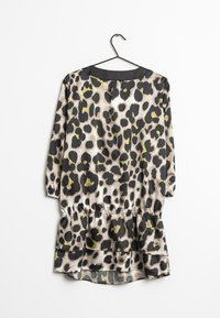 Leopardprint kjole med trekvartærmer, elastisk talje og lagdelt kant. Fremstillet af glat stof i beige, sort og grønne nuancer.