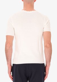 T-shirt bianco a maniche corte con motivo a maglia testurizzato e collo rotondo a costine, con taglio dritto e finitura in tessuto morbido.