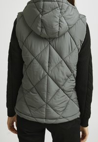Grå quiltad pufferväst med huva, med en texturerad svart stickad design på ärmarna och en boxig passform för komfort och värme.