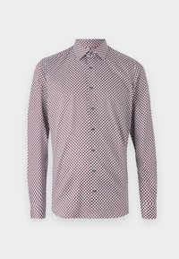 Chemise à manches longues blanche avec un motif géométrique rouge et marine. Comprend un col, des poignets et une coupe droite.