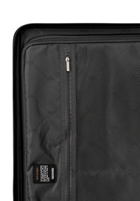 Interno della borsa da viaggio nera con tessuto liscio, scomparti in rete e una tasca con zip. Include un'etichetta in tessuto con le istruzioni per la cura.