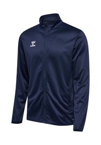 Marineblaue Sportjacke mit durchgehendem Reißverschluss, Stehkragen und weißem Hummel-Logo auf der linken Brust, auf weißem Hintergrund dargestellt.