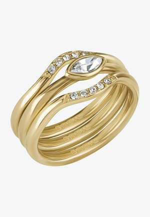 Złota obrączka składająca się z trzech splecionych pasm. Zawiera kamień w kształcie marquez i mniejsze przezroczyste kryształki na górze dla dodania detali.