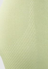 Ljust grön tyg med en strukturerad design som kombinerar släta och honungscombsmönster. Materialet verkar vara stretchigt och andningsbart.