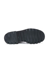 Suola di scarpa in gomma nera con righe orizzontali e scanalature ben definite. Punta arrotondata e leggero arco al centro per supporto.