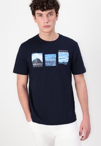 Tamno plava pamučna majica s tri pravokutna grafička otiska s motivima oceana i natpisima. Kratki rukavi i okrugli izrez.