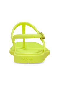 Heldere gele Crocs-sandalen met een breed bandontwerp met een gespsluiting, zachte getextureerde zolen en een gecontourde buitenzool voor comfort.