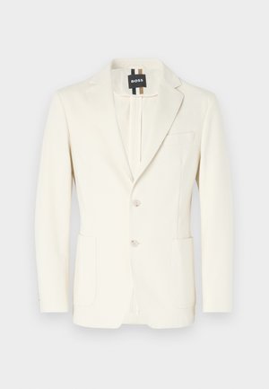 White blazer made of smooth fabric, featuring a notched lapel, two front pockets, button closure, and tag with branding.