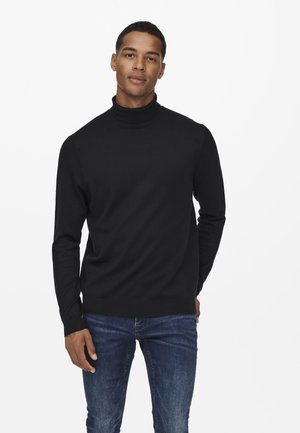 Pulover negru cu guler înalt, dintr-un material tricotat ușor, cu un design ajustat, mâneci lungi, guler și margini cu model canalé, purtat cu blugi albaștri.