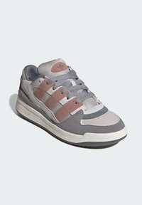 Gray athletic shoe with suede, mesh, and rubber materials. Features pink accents, three side stripes, and a textured outsole.