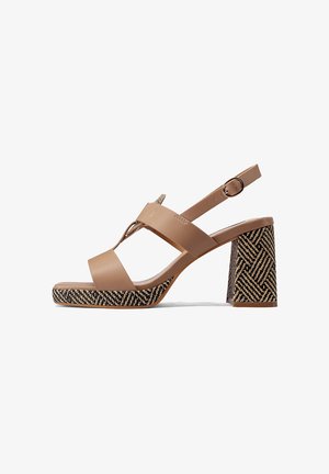 Sandal con tacco in pelle color cuoio, dotato di una fascia ampia e una fibbia alla caviglia; presenta un tacco a blocco con un motivo texturizzato in nero e cuoio.