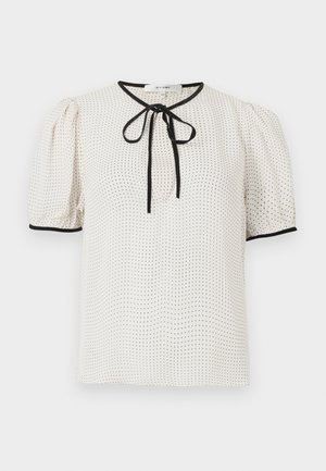 Short-sleeve blouse in light cream with black dotted pattern, round neckline, and tied ribbon detail; features black piping along the edges.