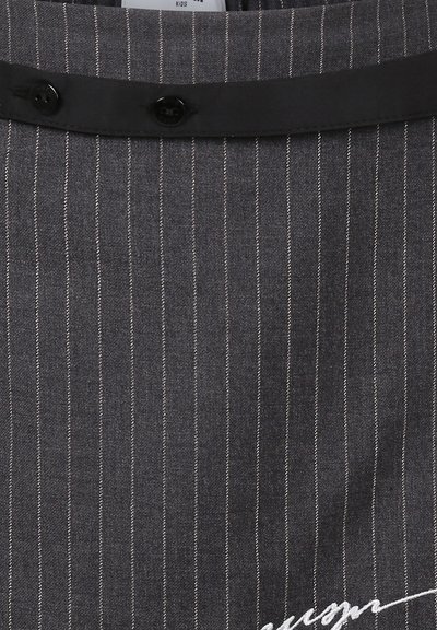 Tissu gris à rayures avec une texture lisse, présentant une taille noire et deux boutons noirs. Un détail de signature en cursive blanche est visible.
