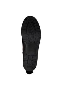 Semelle de chaussure en caoutchouc noir épais et robuste, présentant un motif de semelle texturé pour une traction et une stabilité accrues. Le matériau principal est le caoutchouc.