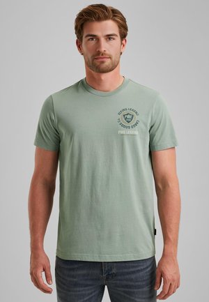 T-shirt en coton vert clair avec des manches courtes. Doté d'un col rond et d'un logo imprimé sur la poitrine gauche. Coupe décontractée.