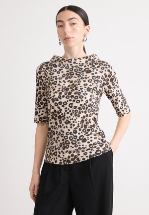 Leopardprint top in lichte stof, met een hoge hals en korte mouwen, gecombineerd met zwarte losse broek.