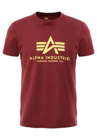 Tricou bordo cu mâneci scurte, cu logo galben Alpha Industries și textul „Knoxville, Tennessee, U.S.A.” centrat în față.