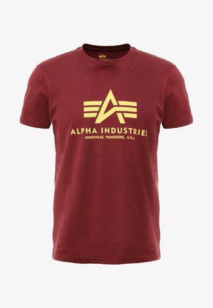 Burgundy színű, rövid ujjú pamut póló, sárga grafikai logóval és a következő felirattal: "Alpha Industries, Knoxville, Tennessee, U.S.A."