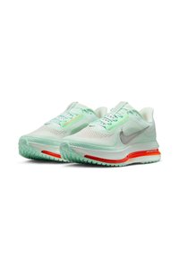 Nike running shoes featuring a light mint green mesh upper, silver swoosh, red accents on sole, and textured outsole for grip.