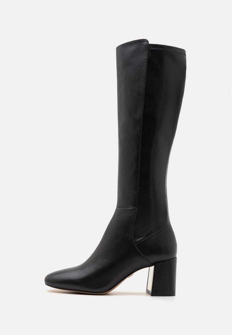 Botte en cuir noir montée jusqu'au genou, à bout pointu, avec un talon carré et une silhouette épurée. Présente des coutures minimales et une texture lisse.
