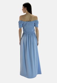 Ljusblå off-shoulder maxiklänning med texturerad rynkad midja och puffärmar, flödande kjol, gjord av mjukt tyg.
