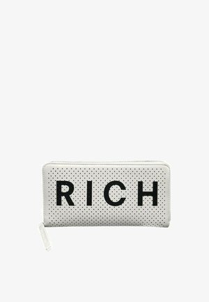 Portefeuille rectangulaire blanc à zip avec des pois noirs et de grandes lettres noires formant le mot « RICH » sur le devant.