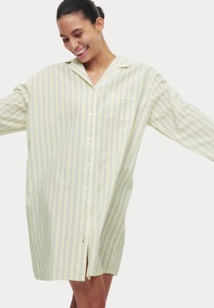 Vestido de camisa a rayas en amarillo claro con botones en la parte delantera, mangas largas y un bolsillo en el pecho; la tela parece suave y ligera.