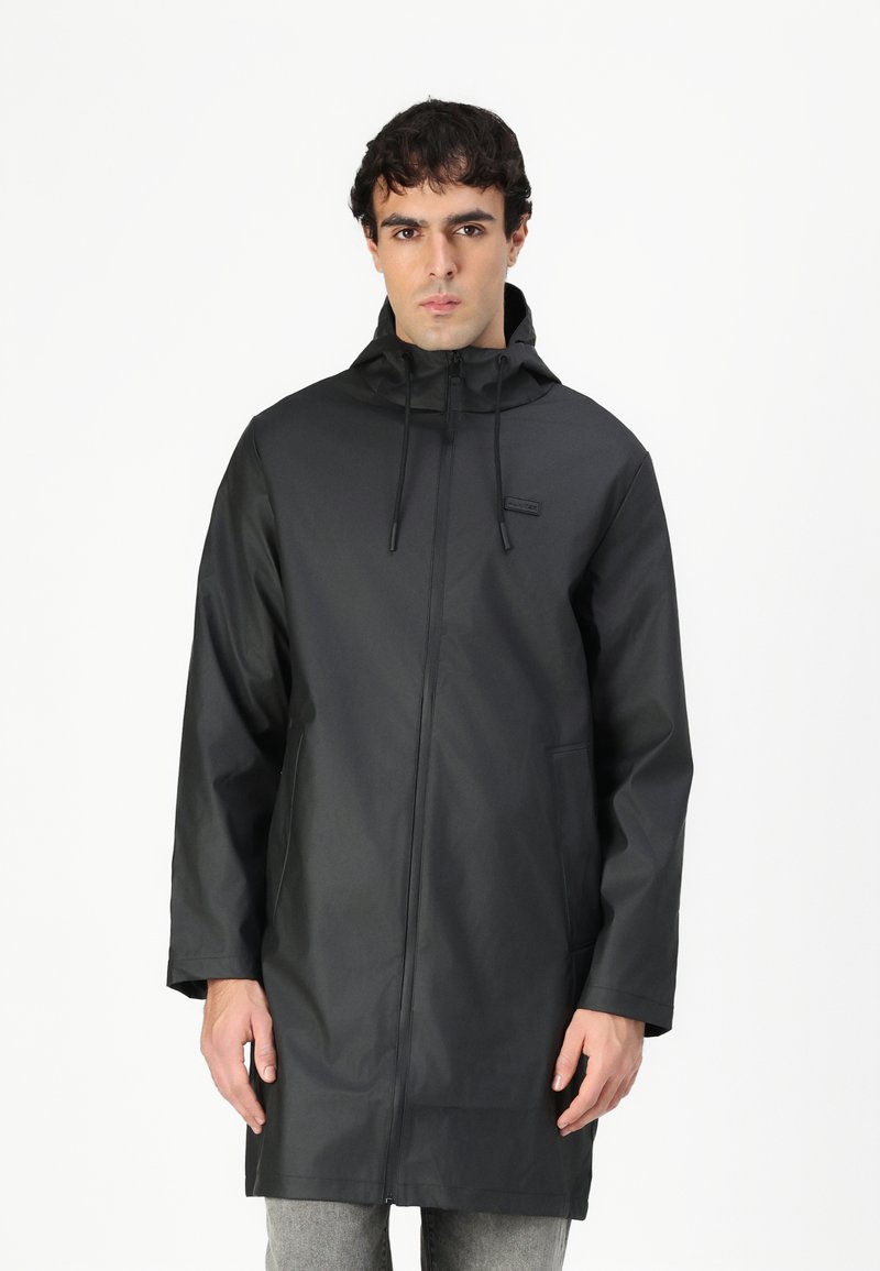 Black waterproof jacket with hood, front zipper closure, adjustable drawstrings, and two side pockets; smooth texture and relaxed fit.