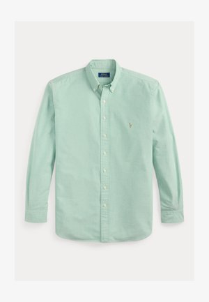 Jasnozielona bawełniana koszula zapinana na guziki z długimi rękawami, kołnierzykiem oraz małym haftowanym logo na lewej piersi.