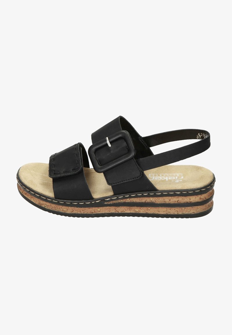 Sandale noire avec boucle et bride réglables, semelle intérieure beige matelassée et semelle en liège superposée avec semelle extérieure en caoutchouc noir.