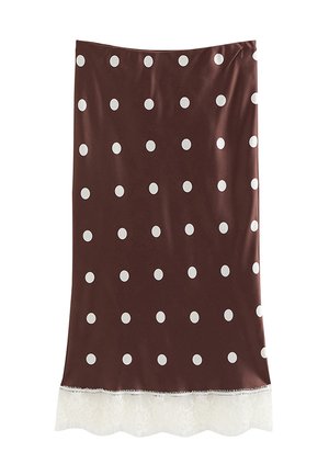 Bruine rok met witte stippen en een witte kanten rand aan de zoom, plat gelegd tegen een witte achtergrond.