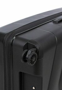 Černý tvrzený kufr s rohem, který obsahuje dvojité inline kolečka, texturovaný povrch a robustní zip. Hladký povrch s minimálními akcenty.