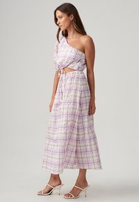 Questo è un vestito a spalla unica, a quadri viola e bianchi, realizzato in tessuto leggero, con vita annodata e gonna fluida.