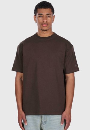 Braunes Baumwoll-T-Shirt mit lässiger Passform, kurzen Ärmeln und Rundhalsausschnitt. Verfügt über dezente Logo-Details auf dem Ärmel.