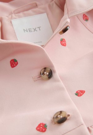 Bluză roz deschis cu broderie cu căpșuni, având un guler ascuțit și nasturi rotunzi, maro. Textură netedă și design casual.