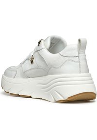 Zapatilla de cuero blanca con una suela gruesa y ondulada. Presenta acentos dorados y detalles texturizados en la parte superior. Diseño minimalista, punta redonda.