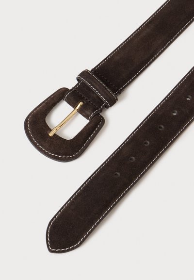 Ceinture en daim marron foncé avec boucle dorée, coutures blanches le long des bords et plusieurs trous de réglage sur fond clair.