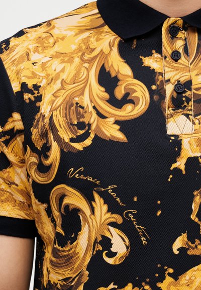 Черна поло риза с златисти барокови листни мотиви и надпис "Versace Jeans Couture", с черна яка и платка с копчета.