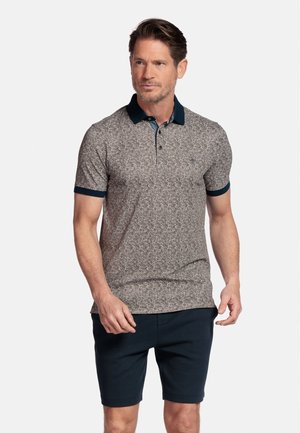 Korte mouw polo shirt met een textuur van een beige en marineblauw bloemenpatroon, voorzien van een marineblauwe kraag en bijpassende manchetten. Draagt in combinatie met donkere shorts.