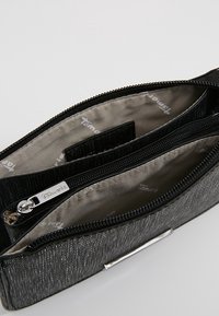 Svart, texturerad kuvertväska med dragkedja. Insidan har en beige foder och flera fack. Inkluderar detaljer i silverfärg.