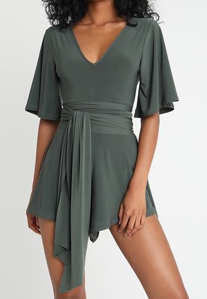 Zielony kombinezon typu wrap z głębokim dekoltem w kształcie litery V, krótkimi, falbankowymi rękawami, paskiem w talii oraz zwiewnym, textured materiałem.