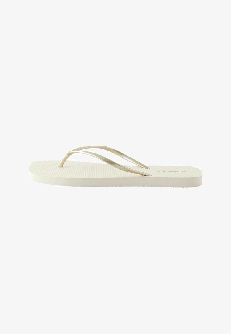 Tongs beige simple avec semelle texturée et lanières fines, vue de côté sur fond blanc.