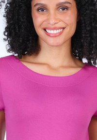 Fuchsia Kurzarmshirt mit weitem, rundem Ausschnitt. Aus weichem Stoff mit glatter Textur, mit dezenten Nahtdetails.