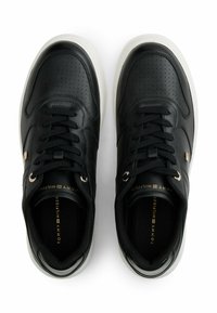 Sneaker nere in pelle con sezioni perforate, punta rotonda, lacci neri, suola in gomma e dettagli dorati sulla linguetta e sul lato.