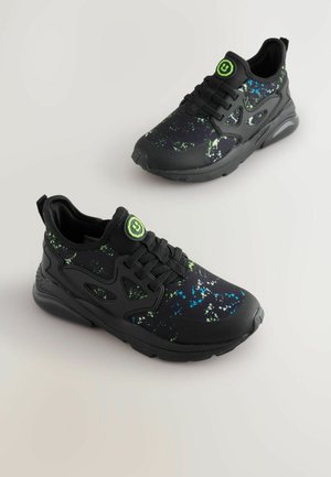 Czarne buty sportowe mają wzór w plamy zieleni i niebieskiego, z solidną podeszwą, teksturowanym materiałem i czarnymi sznurowadłami zapewniającymi pewne dopasowanie.