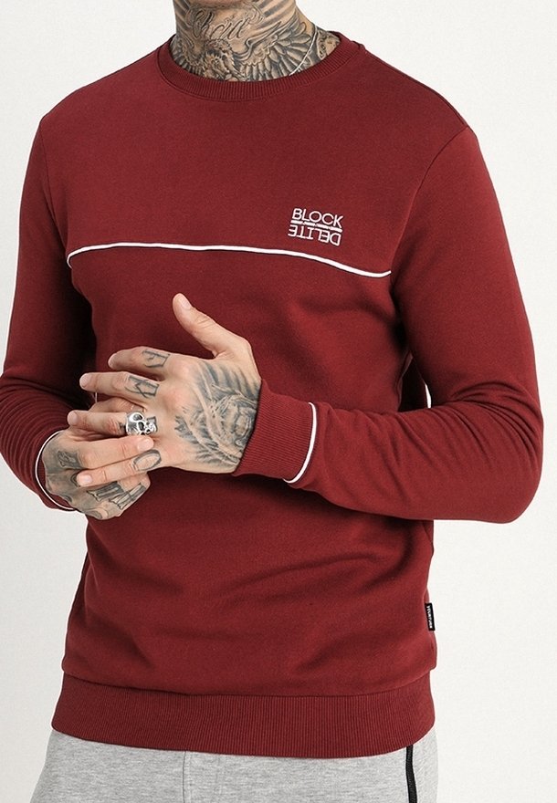 Sudadera burdeos con franja de acento blanca y logo bordado "BLOCK". Puños y dobladillo acanalados, textura suave y diseño clásico de cuello redondo.