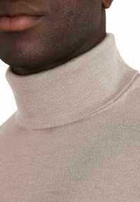 Maglione beige a collo alto con un design aderente, texture morbida e colletto a coste. Il tessuto in maglia presenta dettagli di cucitura sottili e uniformi.