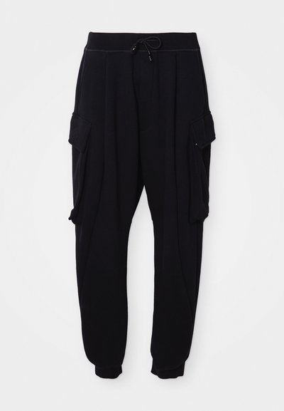 Black jogger pants made from soft fabric, featuring an elastic waistband with a drawstring, side cargo pockets, and ribbed ankle cuffs.