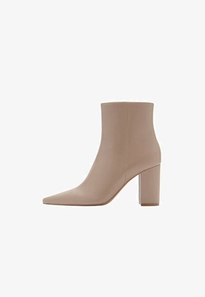 Botín de tobillo beige con punta afilada, hecho de material suave, con un tacón bloque transparente y un diseño minimalista.